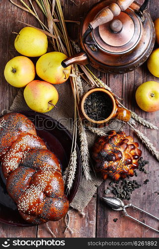 Autumn still life with scones,tea,apples and ears of wheat.