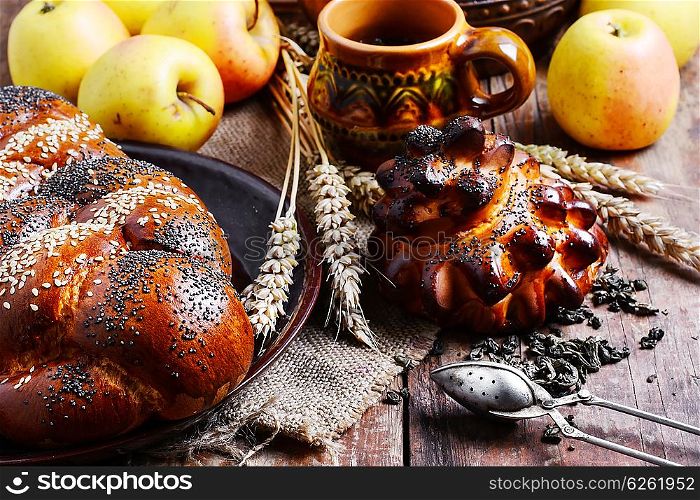 Autumn still life with scones,tea,apples and ears of wheat.