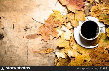 Autumn style. A Cup of hot coffee with maple leaves. On wooden background.. Autumn style. A Cup of hot coffee with maple leaves.