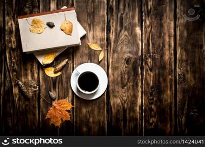 Autumn style. Coffee with an old book. On wooden background.. Autumn style. Coffee with an old book.