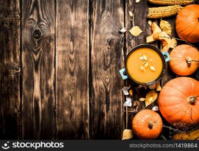 Autumn style. Fresh pumpkin soup. On wooden background. Fresh pumpkin soup.