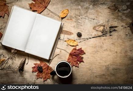 Autumn style. Open book with a hot Cup of coffee. On wooden background.. Autumn style. Open book with a hot Cup of coffee.