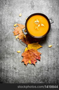 Autumn style. Pumpkin soup from a ripe pumpkin. On the stone table.. Pumpkin soup