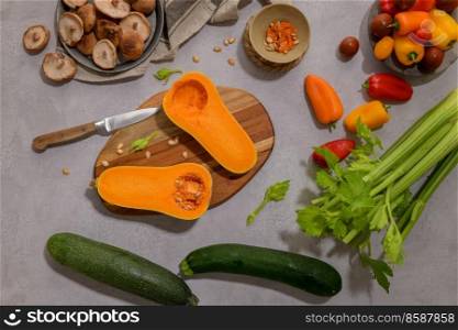 Autumn vegetables arranged on a kitchen worktop while preparing a pumpkin soup.