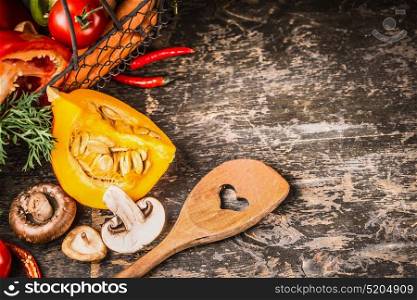 Autumn vegetarian cooking with pumpkin, Mushrooms and vegetables on rustic wooden background with cooking spoon, top view. Healthy food and eating concept