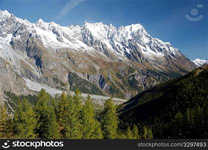 Autumn view of snowcapped peaks in an alpine valley. Gran Jourasses (Mont Blanc massif), Val Veny, Courmayeur, Italy.
