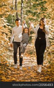 Autumn walk of a young family in the forest.. Dad, mom and daughter are walking in the autumn forest 3367.