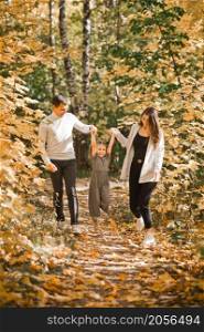 Autumn walk of a young family in the forest.. Dad, mom and daughter are walking in the autumn forest 3368.