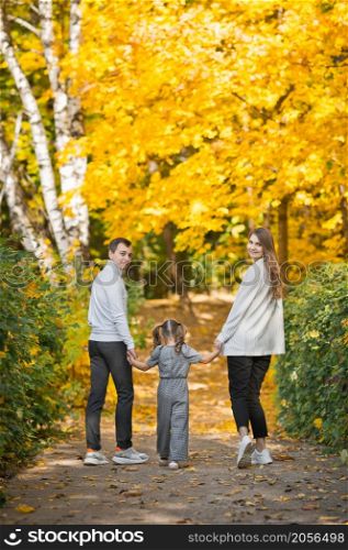 Autumn walk of a young family in the forest.. Dad, mom and daughter are walking in the autumn forest 3391.