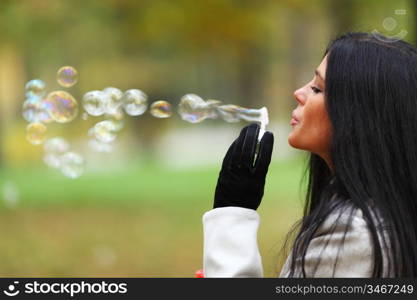 autumn woman blow bubbles portrait in park