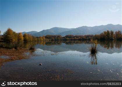 Autumnal colour and mountains reflected in water