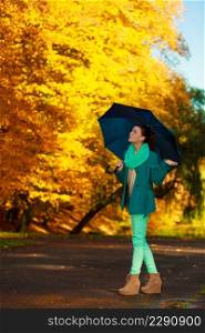 Autumnal fashion concept. Woman walking in park during golden autumn weather, enjoying nature holding umbrella.. Woman walking in park during autumn