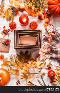 Autumnal flat lay with empty kraft paper boxes, scarf, autumn leaves, pumpkins, candles and cappuccino, top view. Fashion or beauty box. Place for your product. Insta style. Eco friendly packaging