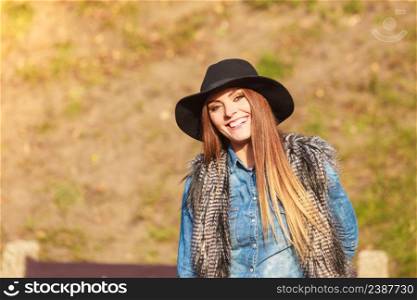 Autumnal happiness idea. Happy cheerful young woman in black hat outdoor. Joyful attractive girl having fun in park.. Cheerful woman having fun outdoors