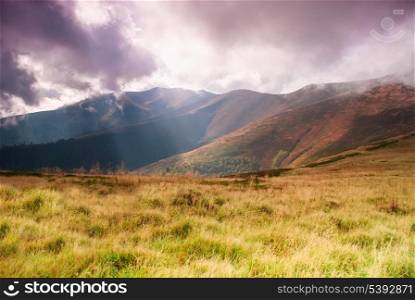 Autumnal hills high up in Carpathian mountains and sunrays