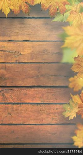 Autumnal leaves over old wooden desk, seasonal banner