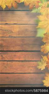 Autumnal leaves over old wooden desk, seasonal banner