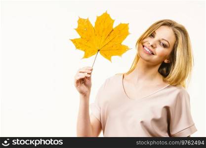 Autumnal natural decorations concept. Woman holding autumn leaf. Studio shot on white background.. Woman holding orange autumn leaf