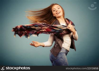 Autumnal outfit concept. Joyful female wearing warm autumn clothing having fun, jumping and dancing. Joyful girl in autumn season clothing