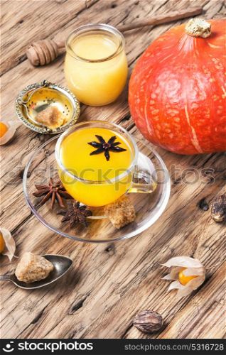 Autumnal Pumpkin Tea. cup with autumn pumpkin tea on retro wood background