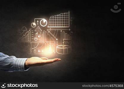 Average sales analysis. Businessman holding digital image of infographs in hand