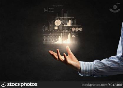 Average sales analysis. Businessman holding digital image of infographs in hand
