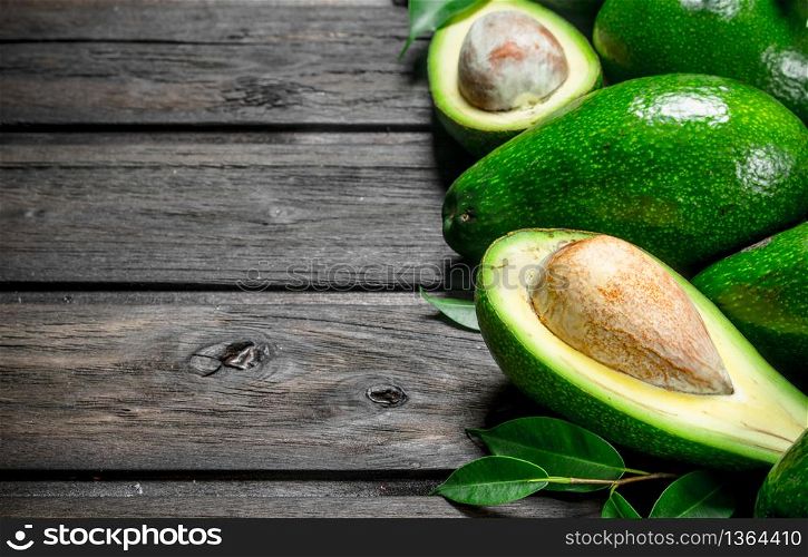 Avocado and avocado halves. On a wooden background.. Avocado and avocado halves.