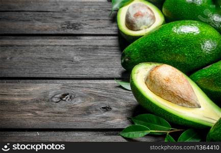 Avocado and avocado halves. On a wooden background.. Avocado and avocado halves.