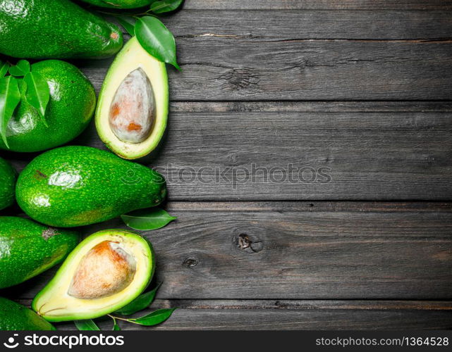 Avocado and avocado halves. On a wooden background.. Avocado and avocado halves.