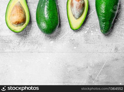 Avocado and avocado halves. On white rustic background.. Avocado and avocado halves