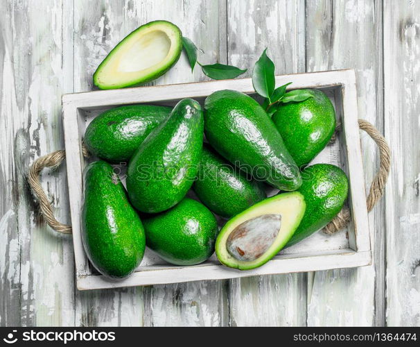 Avocado and avocado slices in white dressing. On a wooden background.. Avocado and avocado slices in white dressing.