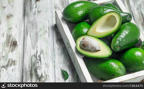 Avocado and avocado slices in white dressing. On a wooden background.. Avocado and avocado slices in white dressing.