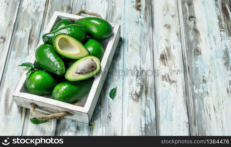 Avocado and avocado slices in white dressing. On a wooden background.. Avocado and avocado slices in white dressing.