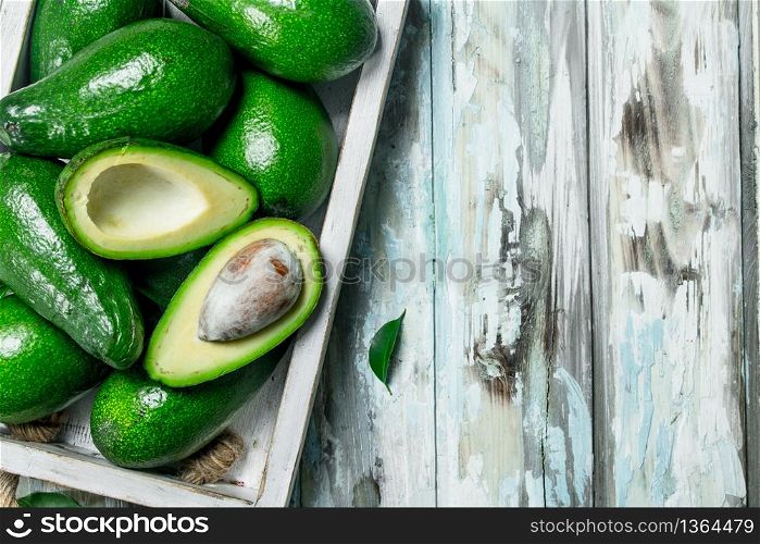 Avocado and avocado slices in white dressing. On a wooden background.. Avocado and avocado slices in white dressing.