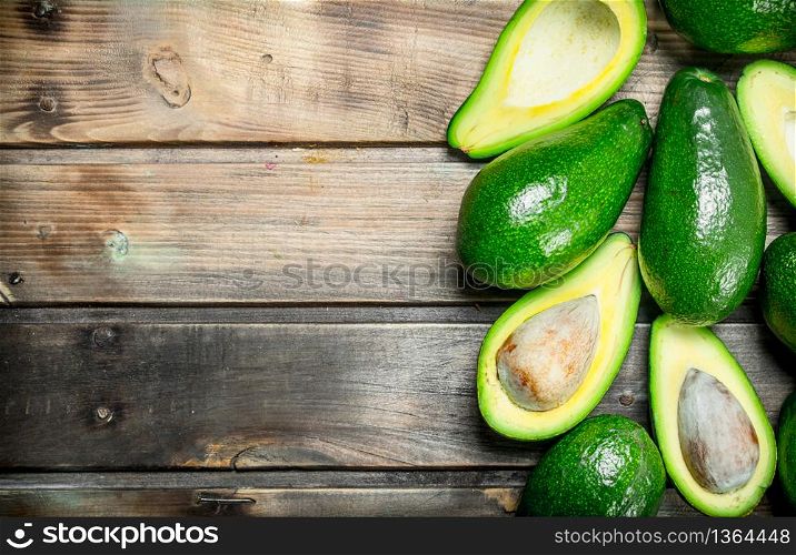 Avocado and avocado slices. On a dark wooden background.. Avocado and avocado slices.
