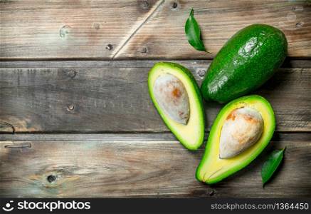 Avocado and avocado slices. On a dark wooden background.. Avocado and avocado slices.