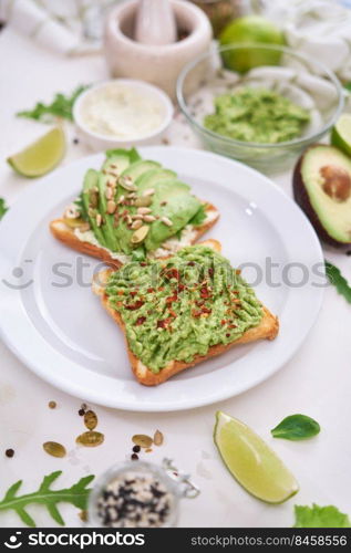 avocado and cream cheese toasts on a plate and ingredients.. avocado and cream cheese toasts on a plate and ingredients