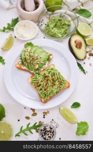 avocado and cream cheese toasts on a plate and ingredients.. avocado and cream cheese toasts on a plate and ingredients