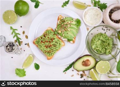 avocado and cream cheese toasts on a plate and ingredients.. avocado and cream cheese toasts on a plate and ingredients