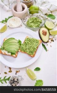 avocado and cream cheese toasts on a plate and ingredients.. avocado and cream cheese toasts on a plate and ingredients