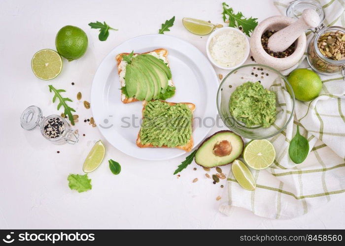 avocado and cream cheese toasts on a plate and ingredients.. avocado and cream cheese toasts on a plate and ingredients