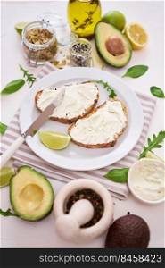 Avocado and cream cheese toasts preparation - grilled or toasted bread with cheese smeared .. Avocado and cream cheese toasts preparation - grilled or toasted bread with cheese smeared 