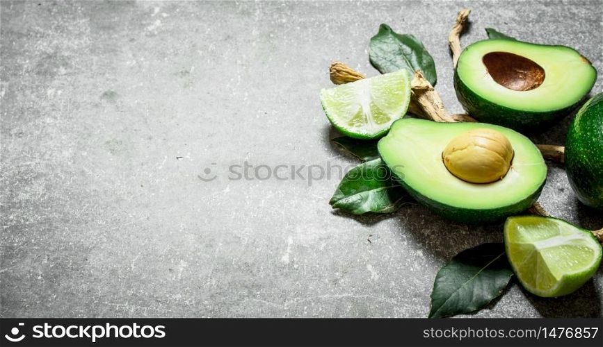 Avocado and lime . On a stone background.. Avocado and lime . On stone background.