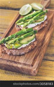 Avocado asparagus toasts with ricotta on cutting board