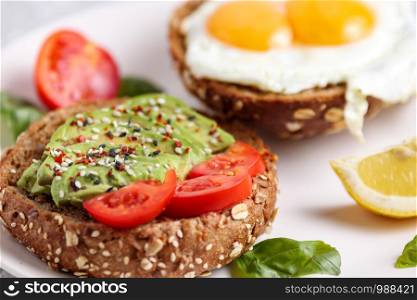 Avocado burger. Vegan toast brunch with egg. Healthy lunch sandwich with green spread. Fitness organic recipe. Light balanced diet dish. Health breakfast snack with basil, tomatoes and chili. Avocado burger. Vegan toast brunch Health sandwich