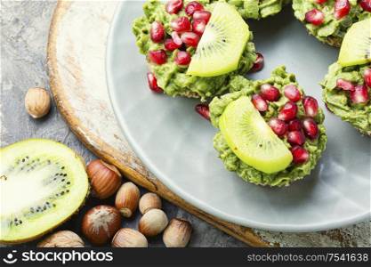 Avocado cupcakes or muffin garnished with kiwi and pomegranate.Cupcakes, close-up.. Cupcake with avocado cream.