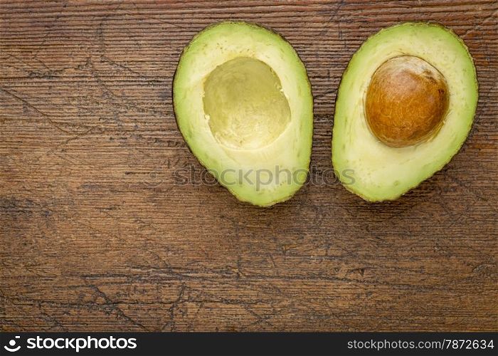 avocado cut in half on a grunge wood with a copy space