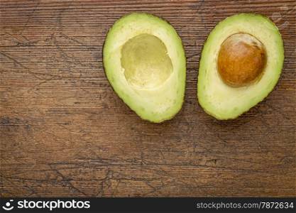 avocado cut in half on a grunge wood with a copy space