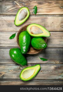 Avocado in a wooden bowl. On a wooden background.. Avocado in a wooden bowl.