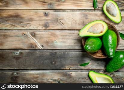 Avocado in a wooden bowl. On a wooden background.. Avocado in a wooden bowl.